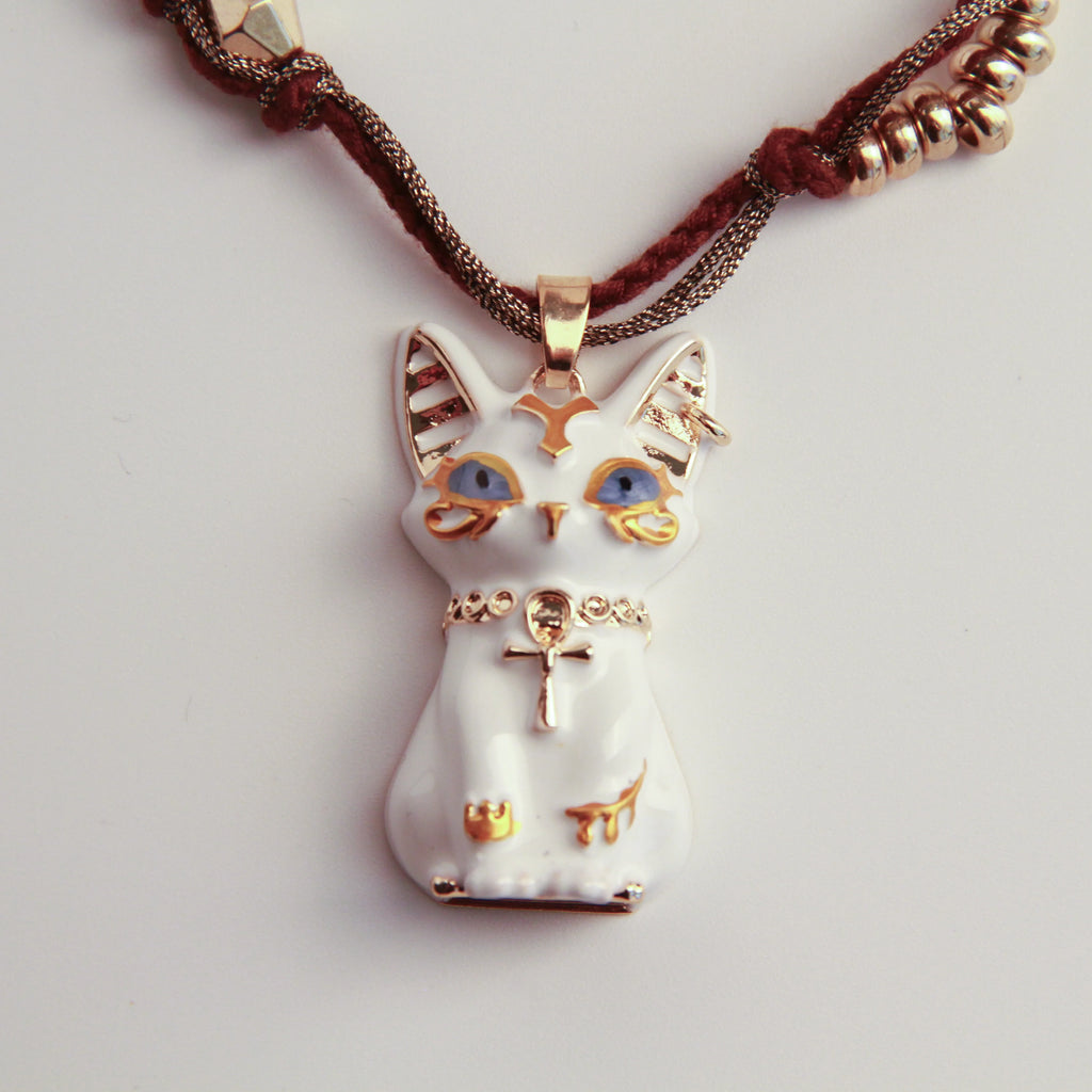 Cat-shaped pendant with gold accents on a white background