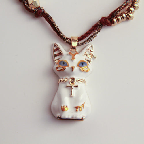 Cat-shaped pendant with gold accents on a white background