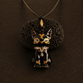 Black cat-shaped pendant with gold accents on a dark brown background