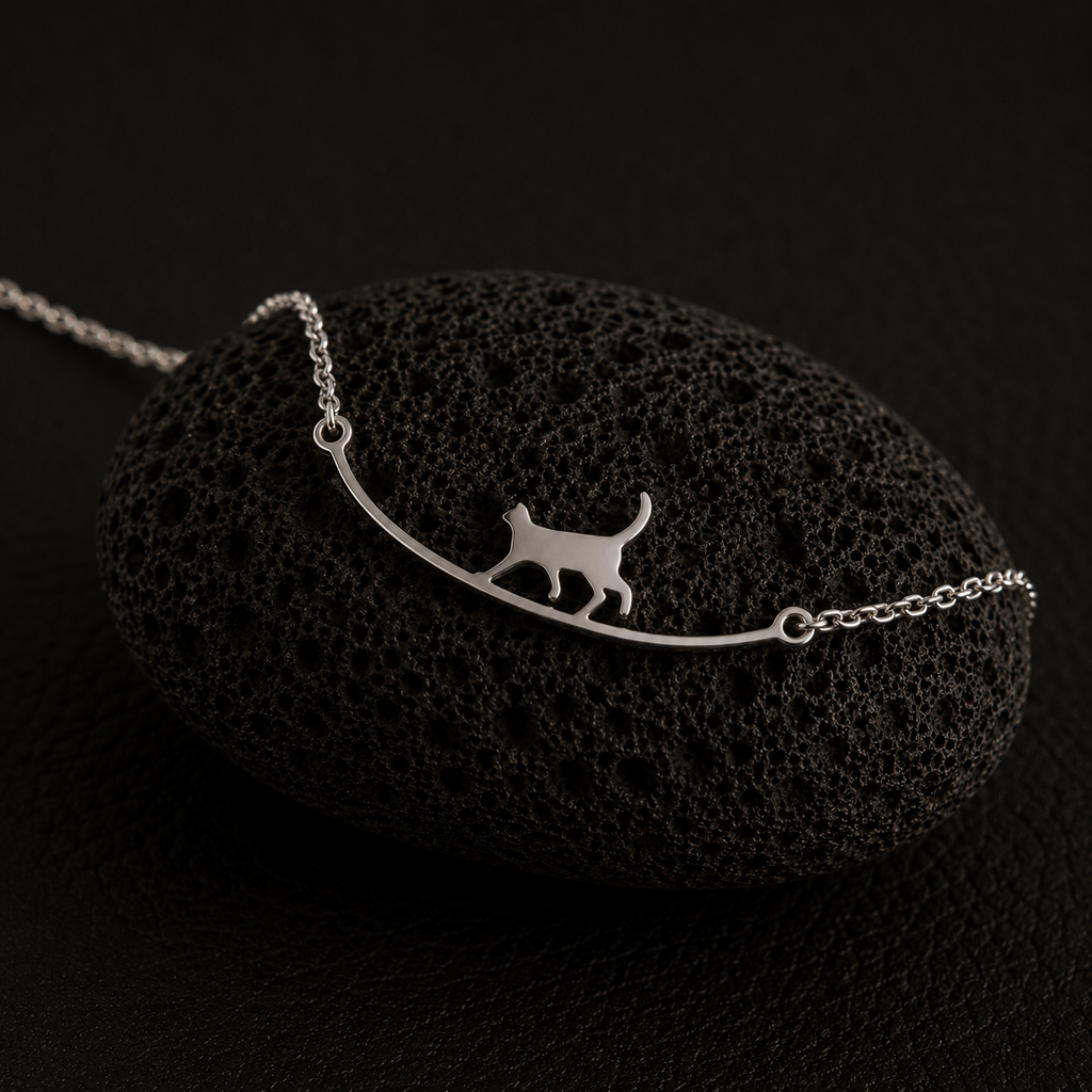 Curious Cat Bracelet displayed on a black lava stone with a dark minimalist background.