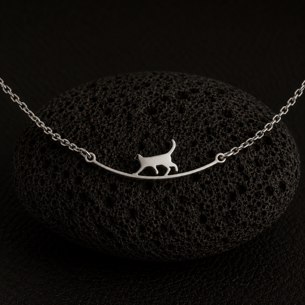Side angle of the Curious Cat Bracelet resting on a black lava stone.