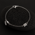 Curious Cat Charm Bracelet in S925 sterling silver displayed on a black lava stone.
