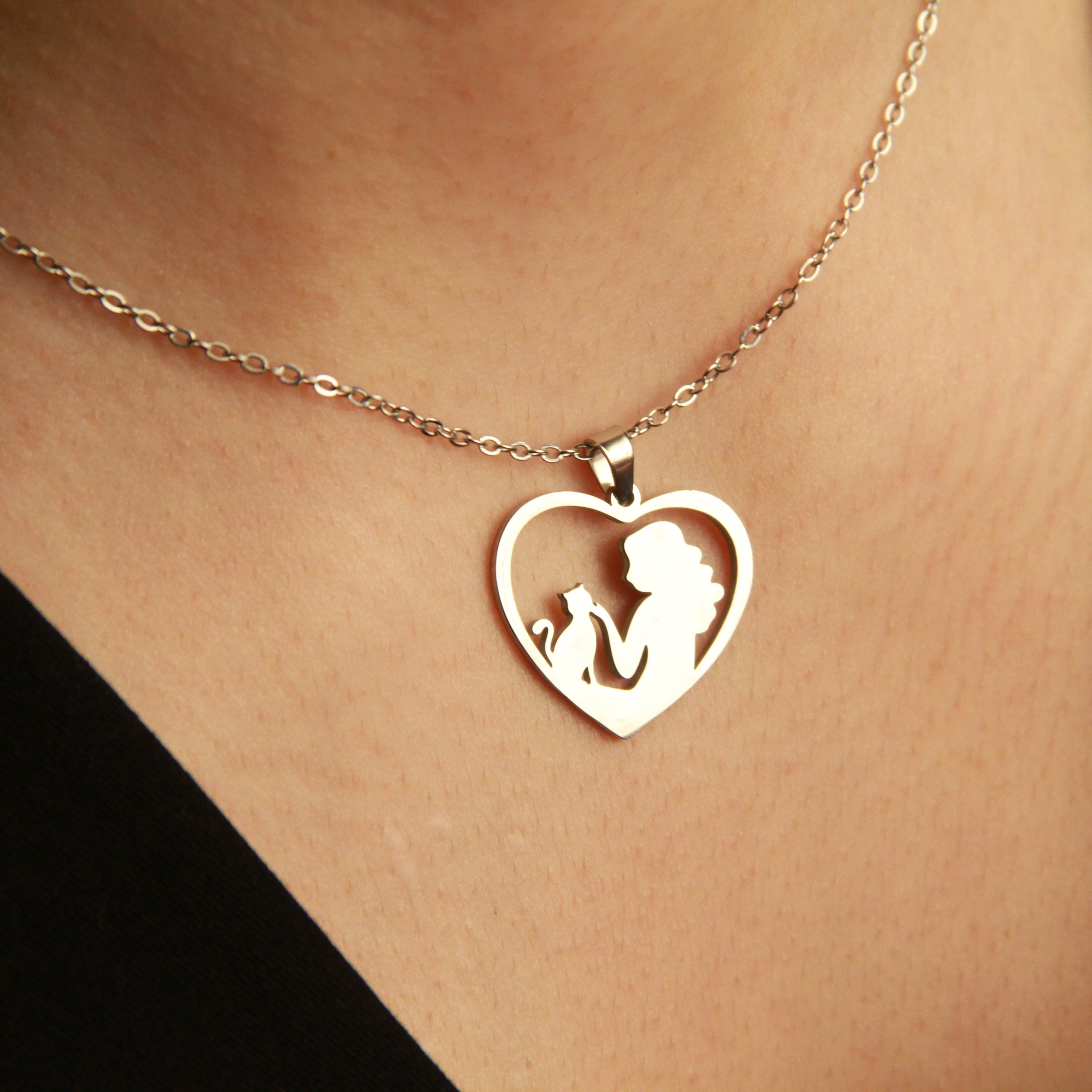 Silver cat pendant necklace featuring a heart frame and feline silhouette, elegant gift for cat lovers