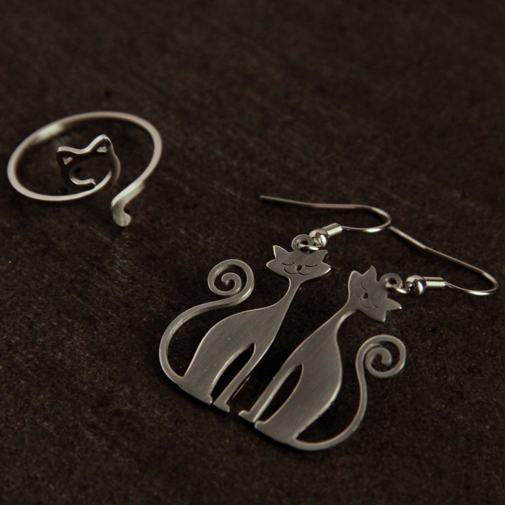 Silver cat jewelry set featuring dangling earrings and adjustable cat ring, stylish accessory collection for women