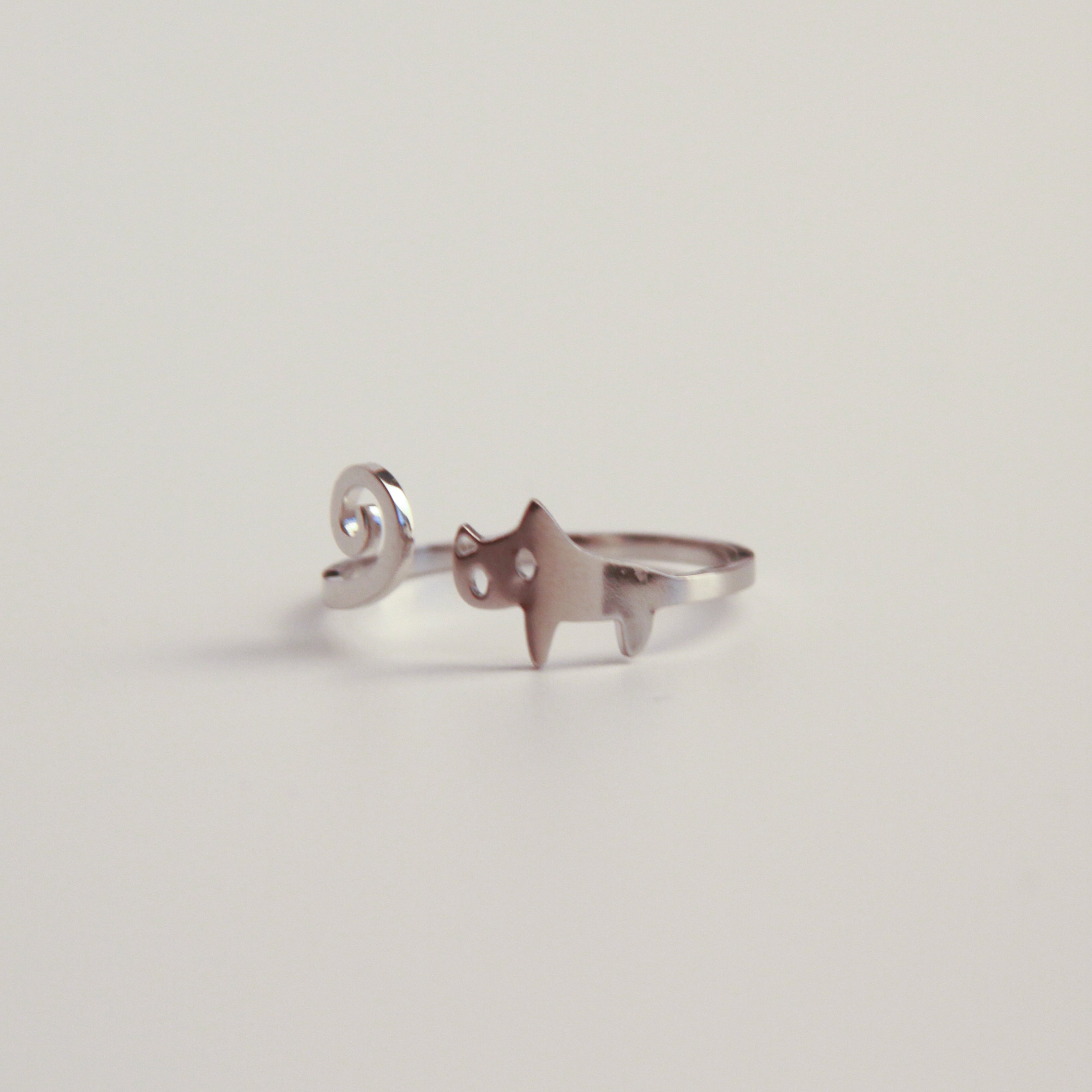 Adjustable silver cat ring with curled tail design, playful cat jewelry