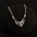 Silver-plated Sphynx Guardian Necklace with a blue-eyed sphynx cat pendant displayed on a black lava stone.
