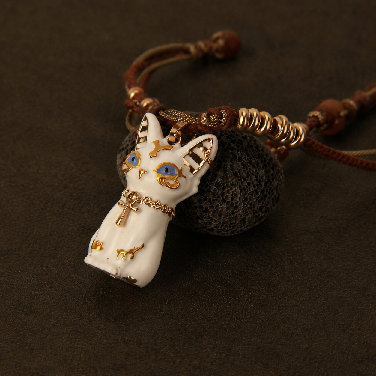 White Bastet cat pendant necklace with brown cord and gold accents