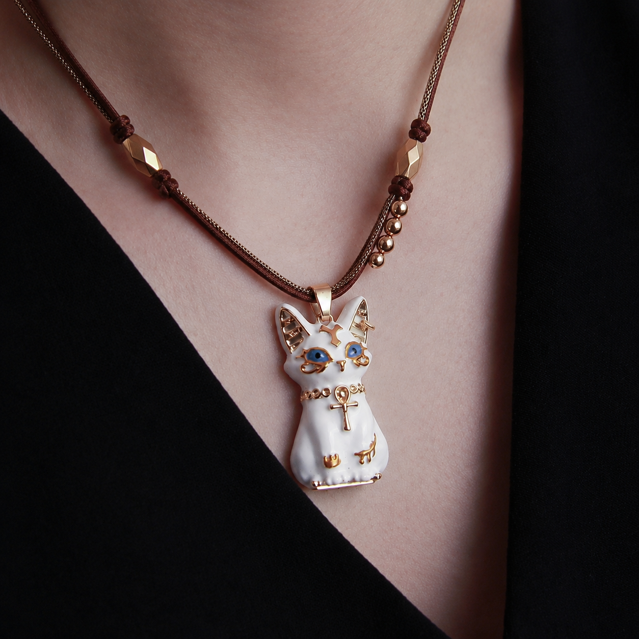 Close-up of white Bastet cat necklace with blue eyes and ankh pendant