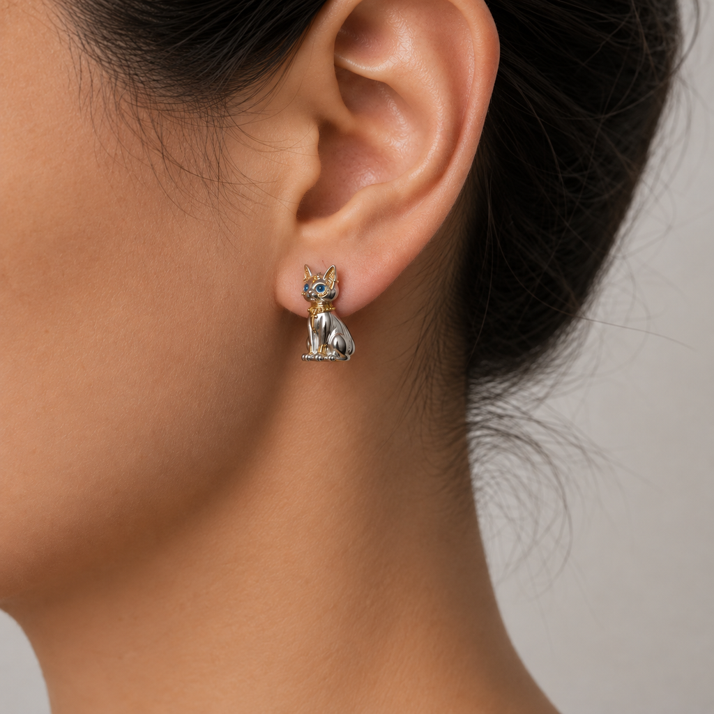 Bastet cat earrings displayed on a black stone in a dark photoshoot