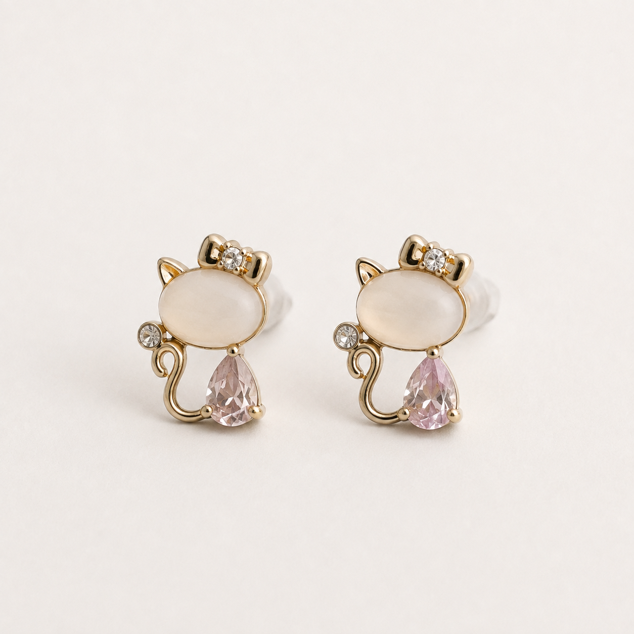 Blush Kitty cat earrings with pink teardrop stones and golden bows
