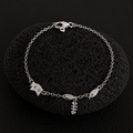 Silver cat charm bracelet with fishbone and fish charms on a delicate chain.