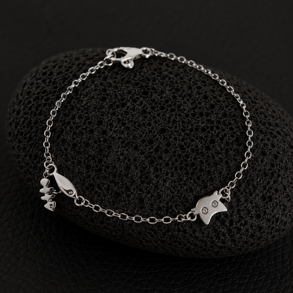 Silver cat charm bracelet with fishbone and fish charms on a delicate chain.