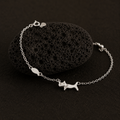 Silver bracelet with a cat charm on a black stone background